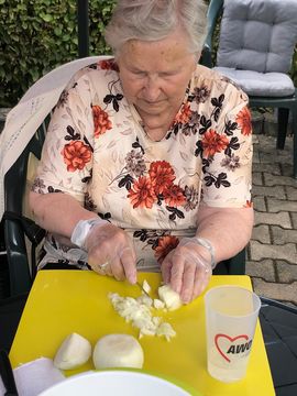 Eine Bewohnerin schneidet Zwiebeln